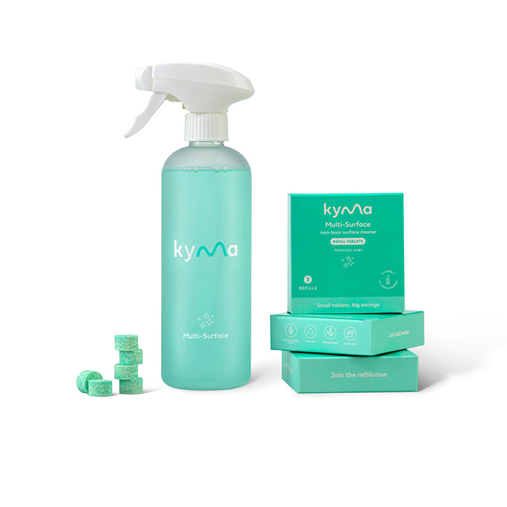 Kyma Multi-Surface Cleaner bundle featuring a turquoise refillable spray bottle and eco-friendly refill tablets stacked beside matching teal packaging boxes labeled “Multi-Surface non-toxic cleaner.”